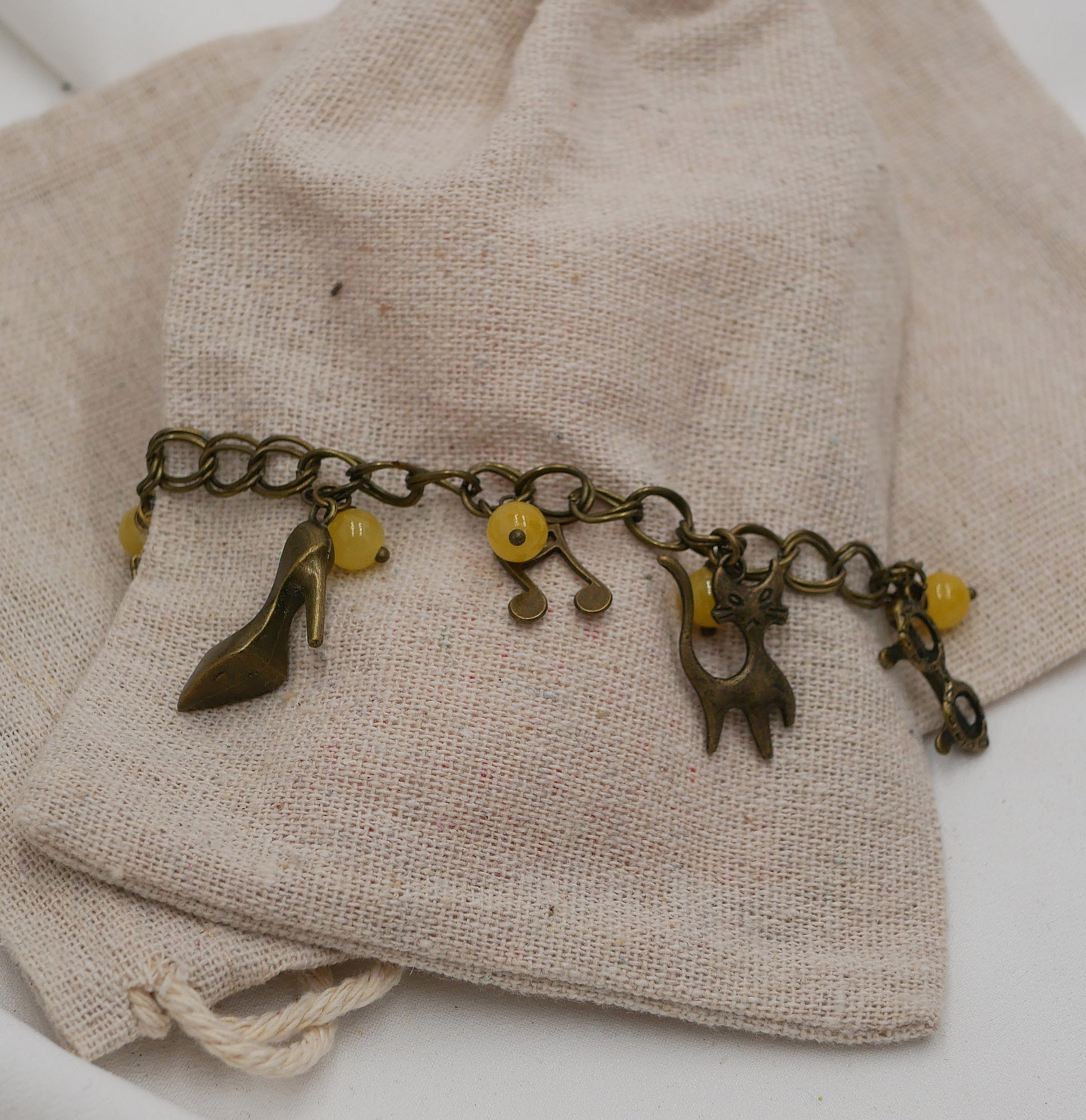 Bracelet aux breloques et perles jaunes sur cha&icirc;ne aux larges anneaux doubles